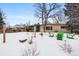 Snowy backyard with patio furniture and covered patio at 6087 S Westview St, Littleton, CO 80120