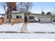 Ranch style home with updated exterior and landscaping; snow covered yard at 6087 S Westview St, Littleton, CO 80120