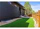 Backyard with artificial grass and a wood table with chairs next to the house at 2777 Ironton St, Denver, CO 80238