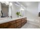 Modern bathroom showcasing a double vanity with wood cabinets, a soaking tub, and stylish fixtures at 2777 Ironton St, Denver, CO 80238