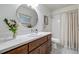 Bathroom with a mirror, vanity, toilet and tiled shower with a shower curtain at 2777 Ironton St, Denver, CO 80238