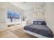 A bedroom with a playful polka dot wall, bright window, and cozy blue bed, creating a cheerful space at 2777 Ironton St, Denver, CO 80238