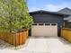 A well-maintained two-car garage featuring a light-colored door and surrounded by mature landscaping at 2777 Ironton St, Denver, CO 80238