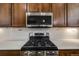 A well-equipped kitchen with stainless steel appliances and modern finishes, showcasing a gas range and microwave at 2777 Ironton St, Denver, CO 80238
