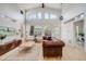 Spacious living room featuring vaulted ceilings, large windows, hardwood floors, and a stylish leather couch at 2777 Ironton St, Denver, CO 80238