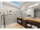 Bright bathroom featuring double vanities, stylish lighting, and framed artwork at 9505 Poundstone Pl, Greenwood Village, CO 80111