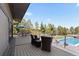 Deck with an outdoor dining table and seating area overlooking a pool and landscaped backyard at 9505 Poundstone Pl, Greenwood Village, CO 80111