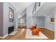 Living room with fireplace, hardwood floors, orange chairs and staircase at 9505 Poundstone Pl, Greenwood Village, CO 80111