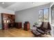 Office features hardwood floors, wooden desk and comfortable seating near a bright window at 9505 Poundstone Pl, Greenwood Village, CO 80111