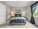 Well-lit bedroom showcases a cozy bed with plush pillows and decorative lamps on nightstands at 16256 Ute Peak Way, Broomfield, CO 80023