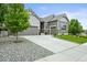 A home with great curb appeal has a well-maintained lawn and a convenient two-car attached garage with stone accents at 16256 Ute Peak Way, Broomfield, CO 80023