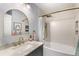 Bathroom with a bathtub, white tile, and a stylish mirror at 4150 S Rome St, Aurora, CO 80018