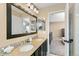 Bathroom featuring dual sinks, large mirror, and access to the main bedroom at 4150 S Rome St, Aurora, CO 80018