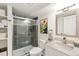 Modern bathroom featuring tiled walk-in shower, stylish vanity, and decorative mirror at 4150 S Rome St, Aurora, CO 80018