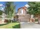 Charming two-story home with a well-maintained lawn, mature trees, and a two-car garage at 4150 S Rome St, Aurora, CO 80018