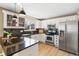 Bright kitchen featuring granite counters, stainless appliances, and black tile backsplash at 4150 S Rome St, Aurora, CO 80018