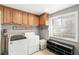 Functional laundry room with front-loading washer and dryer and built in shelving at 4150 S Rome St, Aurora, CO 80018