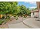 Landscaped backyard featuring mature trees, gravel beds, and a concrete patio, creating a serene outdoor space at 2069 Garrison St, Lakewood, CO 80215
