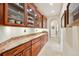 Hallway featuring a granite countertop, wooden cabinets, and glass door shelving at 2069 Garrison St, Lakewood, CO 80215