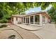 Exterior view of sunroom featuring large windows, a concrete patio, and gravel landscaping at 2069 Garrison St, Lakewood, CO 80215