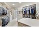 Spacious walk-in closet with custom shelving, drawers, and ample hanging space at 2069 Garrison St, Lakewood, CO 80215
