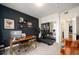 Stylish home office with dark accent wall, modern desk setup, and exercise equipment at 111 S Monroe St # B104, Denver, CO 80209