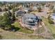 Aerial view showcases backyard with patio, fire pit, mature trees, and picturesque fencing at 404 Yarrow Pl, Castle Pines, CO 80108
