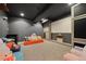 Spacious playroom with gray carpet, black ceiling, an orange couch, and a white wall projection screen at 404 Yarrow Pl, Castle Pines, CO 80108
