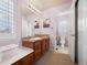 Well-lit bathroom with a wood vanity, mosaic tile backsplash, and a separate toilet room for added privacy at 404 Yarrow Pl, Castle Pines, CO 80108