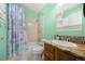Bathroom featuring a shower-tub, single vanity, and refreshing green walls at 404 Yarrow Pl, Castle Pines, CO 80108