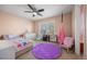 Bright bedroom featuring a ceiling fan, a cozy reading corner, and a large window with shuttered blinds at 404 Yarrow Pl, Castle Pines, CO 80108