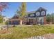 Charming two-story home boasts a beautifully landscaped yard, brick accents, and a welcoming entrance at 404 Yarrow Pl, Castle Pines, CO 80108