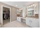 Main bathroom with double vanity, walk-in closet, and neutral tiling at 404 Yarrow Pl, Castle Pines, CO 80108