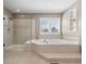 Bright main bathroom featuring a soaking tub, glass-enclosed shower, and serene ambiance at 404 Yarrow Pl, Castle Pines, CO 80108