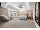 Spacious main bedroom featuring a tray ceiling, sitting area, and large windows at 404 Yarrow Pl, Castle Pines, CO 80108
