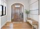 Inviting entryway featuring a wooden front door with sidelights, hardwood floors, bench seating, and stylish decor at 15322 Irving Ct, Broomfield, CO 80023