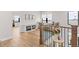 Open hallway featuring hardwood floors, wood banister, and a view of an adjacent living area at 15322 Irving Ct, Broomfield, CO 80023