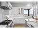 Well-lit kitchen with custom white cabinetry, marble counters, stainless steel appliances, and a large sink at 15322 Irving Ct, Broomfield, CO 80023