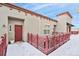 Inviting entryway featuring a red door, decorative fence, and snowy patio at 1767 N Pearl St # 308, Denver, CO 80203