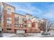 Modern brick apartment building with balconies, an attached garage, and well-kept landscaping, all under a clear blue sky at 1767 N Pearl St # 308, Denver, CO 80203