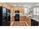 Efficient kitchen featuring light wood cabinets, quartz countertops, black appliances, and neutral flooring at 1767 N Pearl St # 308, Denver, CO 80203