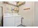 Efficient laundry room with a front-load washer and dryer, shelving, and decorative tile floor at 1767 N Pearl St # 308, Denver, CO 80203
