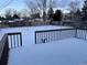 Spacious backyard with snow covered lawn, wooden deck, and mature trees at 3062 S Florence Ct, Denver, CO 80231