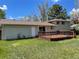 The backyard has a wooden deck, a door, a sliding glass door, windows, and green lawn at 3062 S Florence Ct, Denver, CO 80231