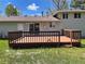 Relax on this deck! The yard features a door, a sliding glass door, windows, and green lawn at 3062 S Florence Ct, Denver, CO 80231