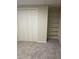 Finished basement with grey carpet, closet and built-in shelving at 3062 S Florence Ct, Denver, CO 80231