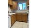 Oak kitchen cabinets, white appliances, and tile floor at 3062 S Florence Ct, Denver, CO 80231