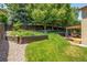 Landscaped backyard has a large lawn, tiered retaining walls, and a covered patio with seating at 19815 E Progress Ln, Centennial, CO 80015