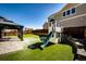 Backyard featuring artificial turf, a stone retaining wall, gazebo and a playhouse with a slide at 7150 E 121St Pl, Thornton, CO 80602