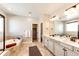 Bathroom featuring double vanity sinks, decorative lights, soaking tub and tile floors at 7150 E 121St Pl, Thornton, CO 80602